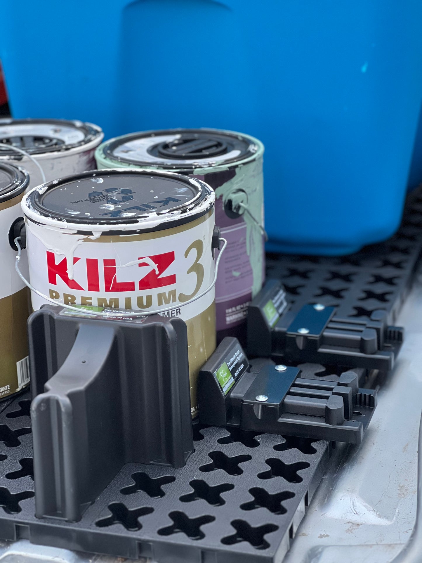 Paint cans and a ladder secured in the back of a pickup with a Tmat cargo system.